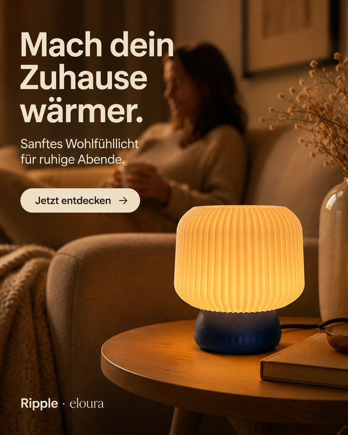 Ripple Tischleuchte in Indigo auf einem Beistelltisch, im Hintergrund eine Frau entspannt auf dem Sofa – Instagram-Grafik „Mach dein Zuhause wärmer.“